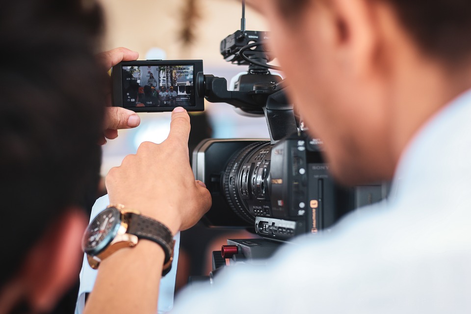 homme derrière une caméra qui filme